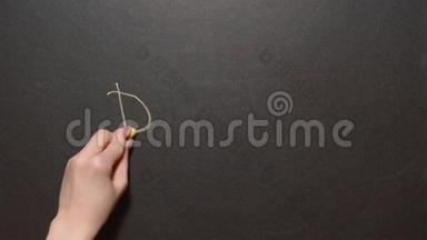 丹克！ 一只左雌手写着丹克`字！用黄色粉笔在黑板上`。 概念粉笔画